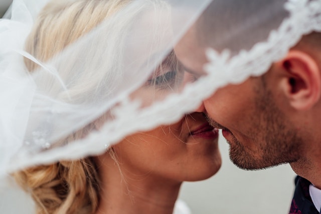 Muž a žena sa bozkávajú pod bielym závojom.jpg