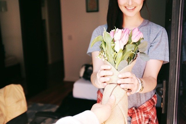 Muž dáva žene kyticu z ružových tulipánov.jpg